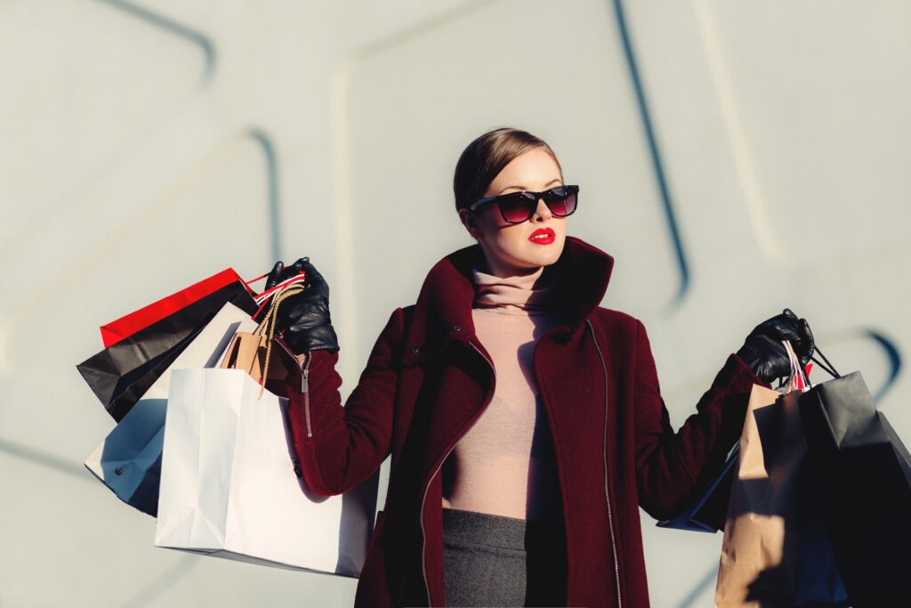 woman in sunglasses holding shopping bags